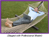 Man resting in a hammock with a laptop computer on his lap (Staged with Professional Model).